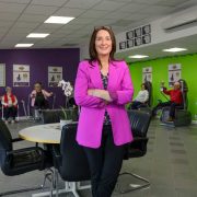 Hello Good Life Ireland founder standing in a healthy ageing hub as members use power-assisted exercise equipment to improve strength, mobility and wellbeing.