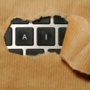 Artificial intelligence and prompt engineering concept with AI keyboard keys behind torn paper, symbolising better prompts for improved business AI performance.