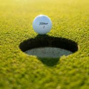 Golf ball beside a hole on a putting green, illustrating the Ryder Cup partnership between Stripe and golf’s premier team competition.