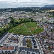 Aerial view of the Cherrywood residential development in Dublin, showing newly built houses, apartment blocks, landscaped green spaces, road networks, and ongoing construction as housing development continues across the area.