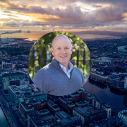 Neil Hughes of Azets Ireland pictured against Dublin Docklands as the firm calls for a €5bn SME growth fund and €350m AI skills investment in Budget 2027.
