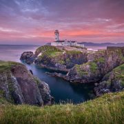 Scenic view of Fanad Head Lighthouse and the rugged Donegal coastline at sunset, highlighting the natural beauty, tourism appeal and economic potential of County Donegal, Ireland.