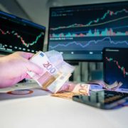 Investor holding euro banknotes in front of financial market charts, illustrating venture capital funding, startup investment and Irish scale-up growth.