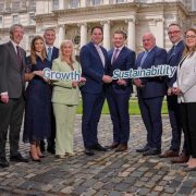 Group marking the Growth and Sustainability Loan Scheme expansion, holding &ldquo;Growth&rdquo; and &ldquo;Sustainability&rdquo; signs outside a government building.