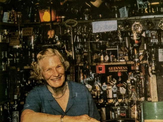 Picture of a woman smiling behind a bar in Donegal.