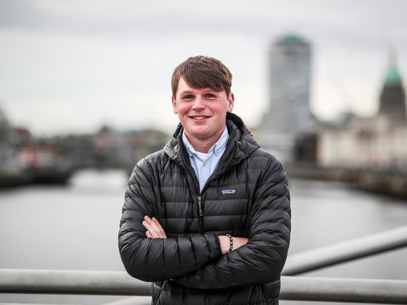 Young man standing on a bridge over River Liffey in Dublin.