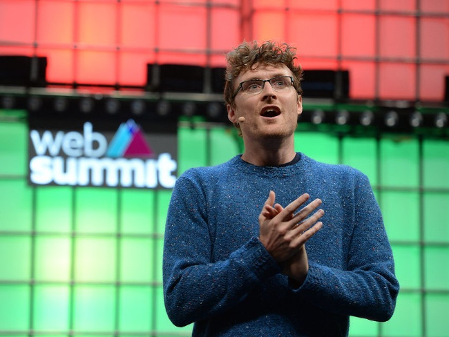 Man in glasses and woolly jumper on stage at Web Summit.