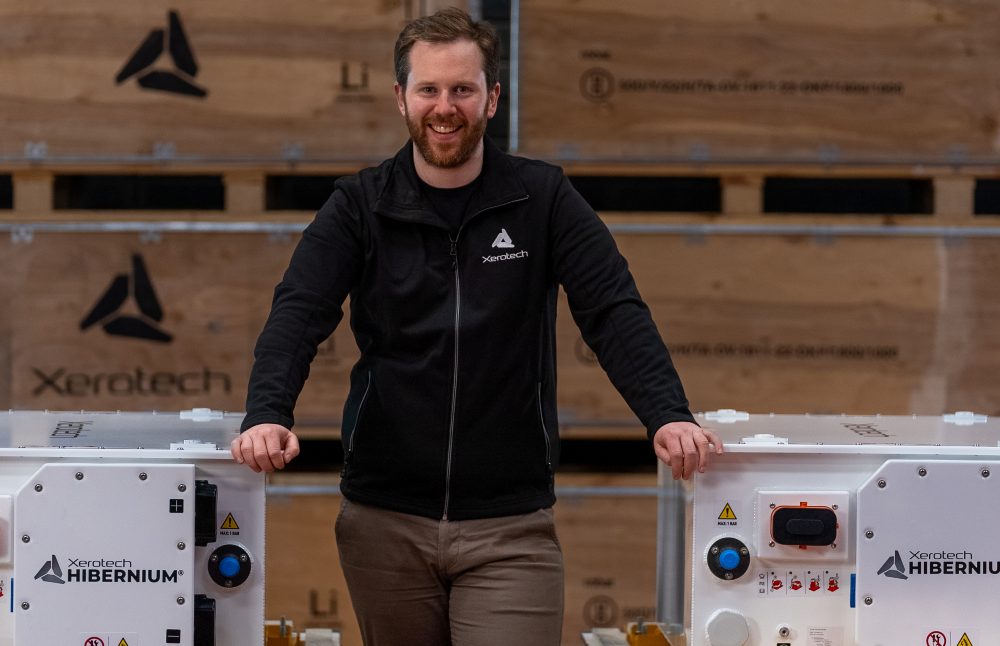 Man standing between large battery systems.