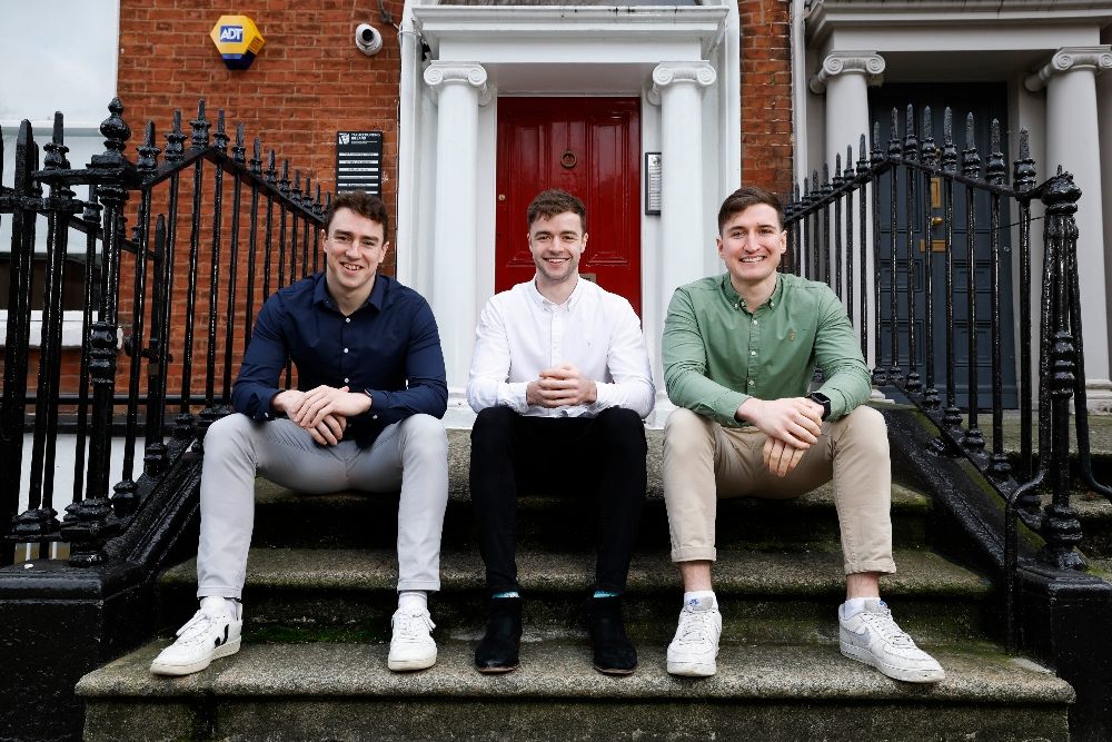 three men sitting on a step.