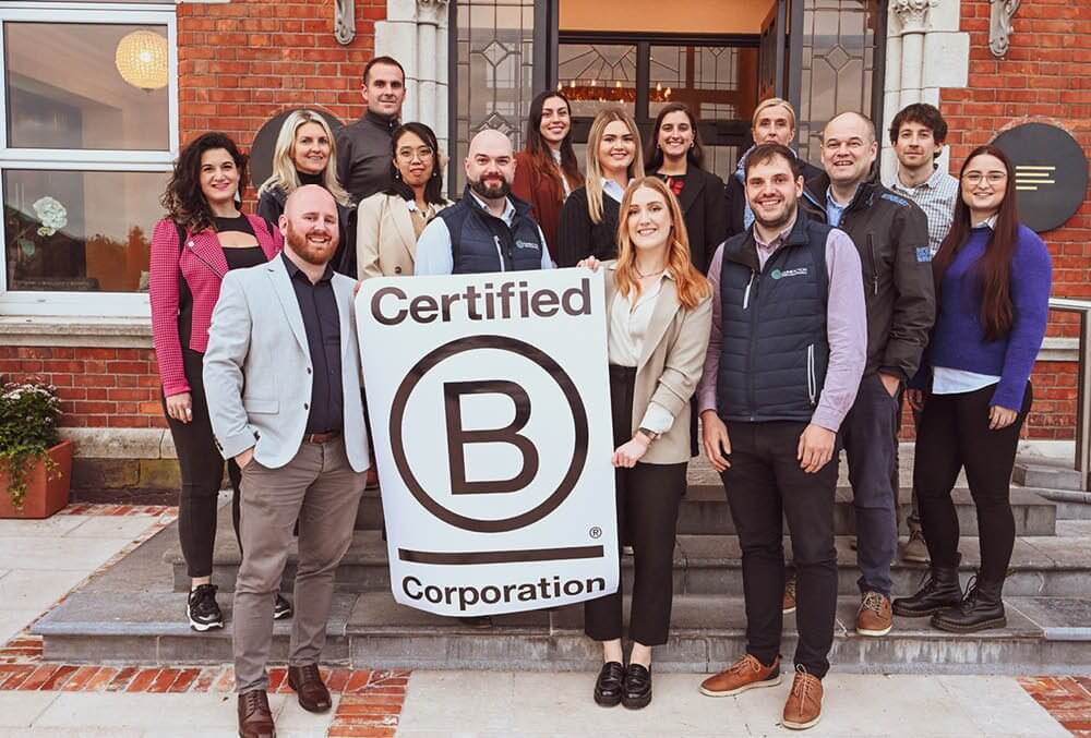 Group of people holding a Certified B flag.
