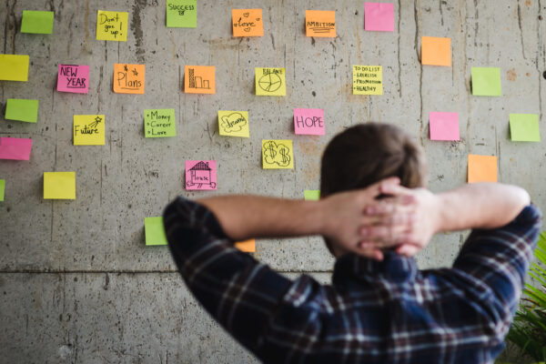 Founder looking at sticky notes on a wall.