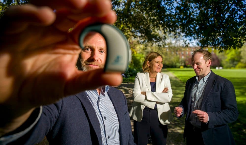 Man holding wearable medical device for treating vertigo.