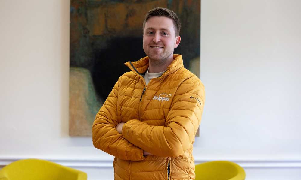 Man in yellow jacket with arms folded.