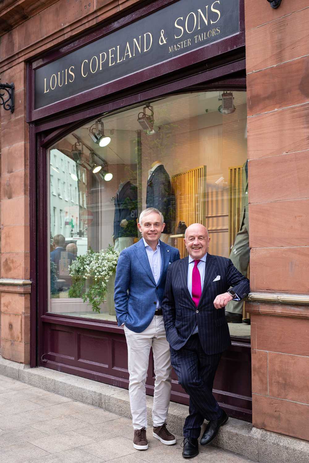 Two men outside a menswear shop.