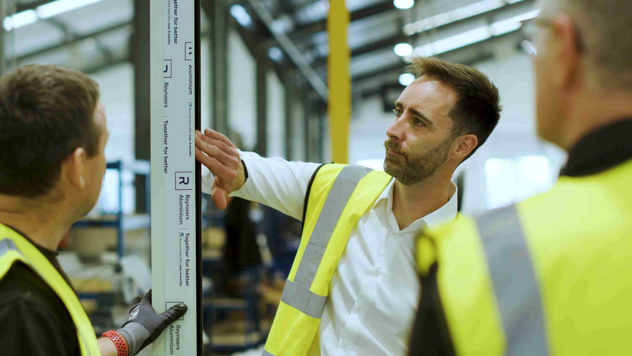 Men in hi-vis jackets inside a factory.