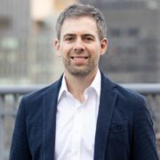 Man in navy blazer and white shirt.