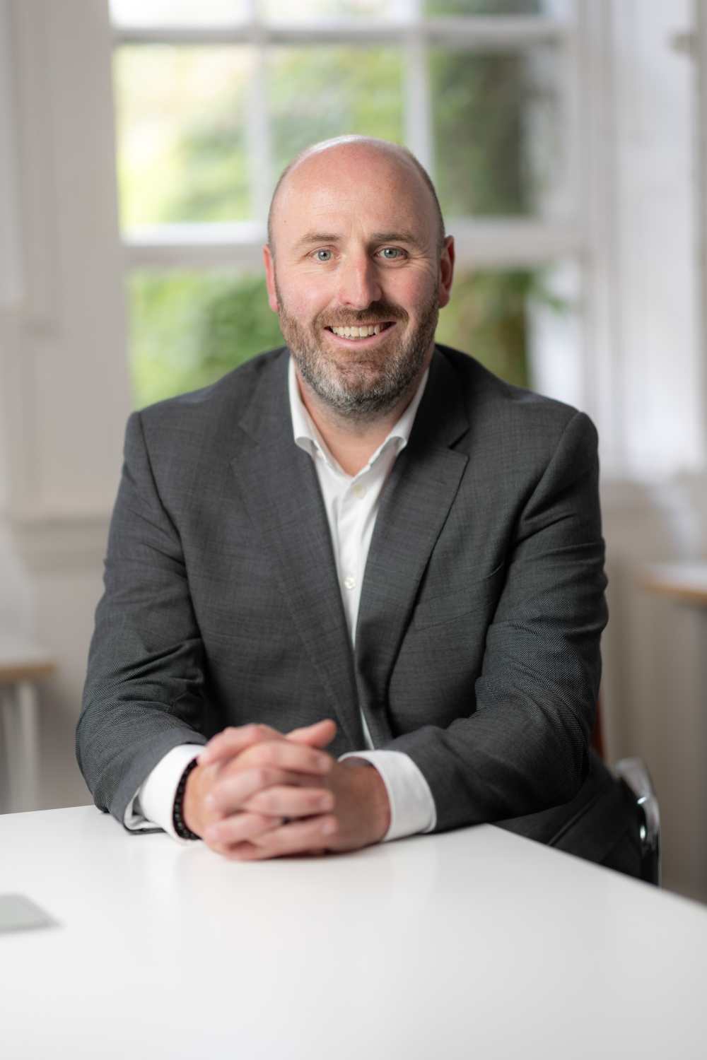 Bearded man in grey suit.