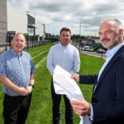 Three men outside a retail park.