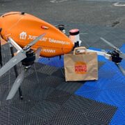 Orange coloured drone with a Burger King delivery.