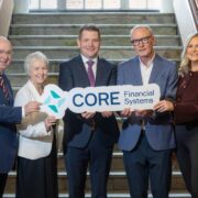 Two women and three men holding a Core Financial Services sign.