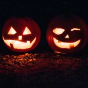 Two carved pumpkins with candles inside.